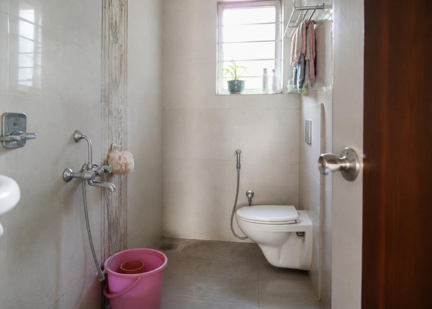 A bright, neatly kept everyday Indian family bathroom with chrome fittings
